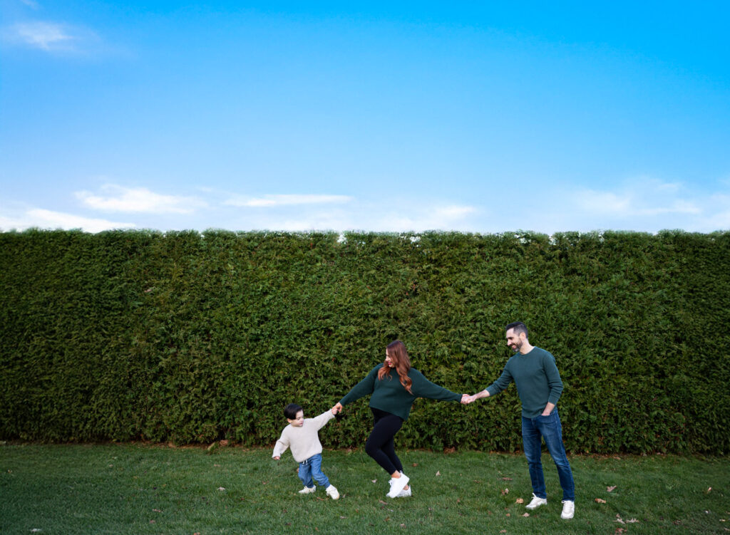 Happy family playing together outdoors on a sunny day in a green field.