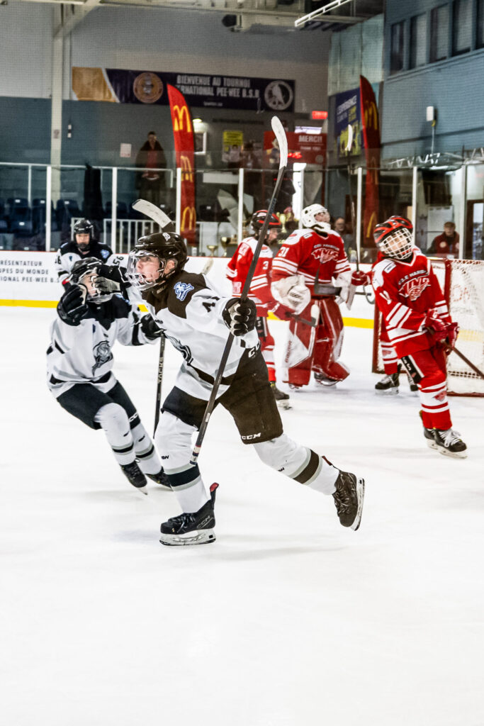 Youth hockey players competing on the ice rink with energy, teamwork, and determination.