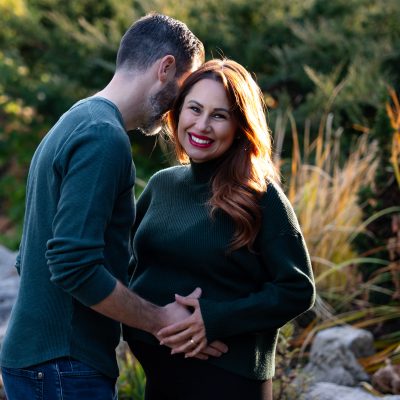 Expecting couple embracing outdoors at golden hour, celebrating love, pregnancy, and new beginnings.